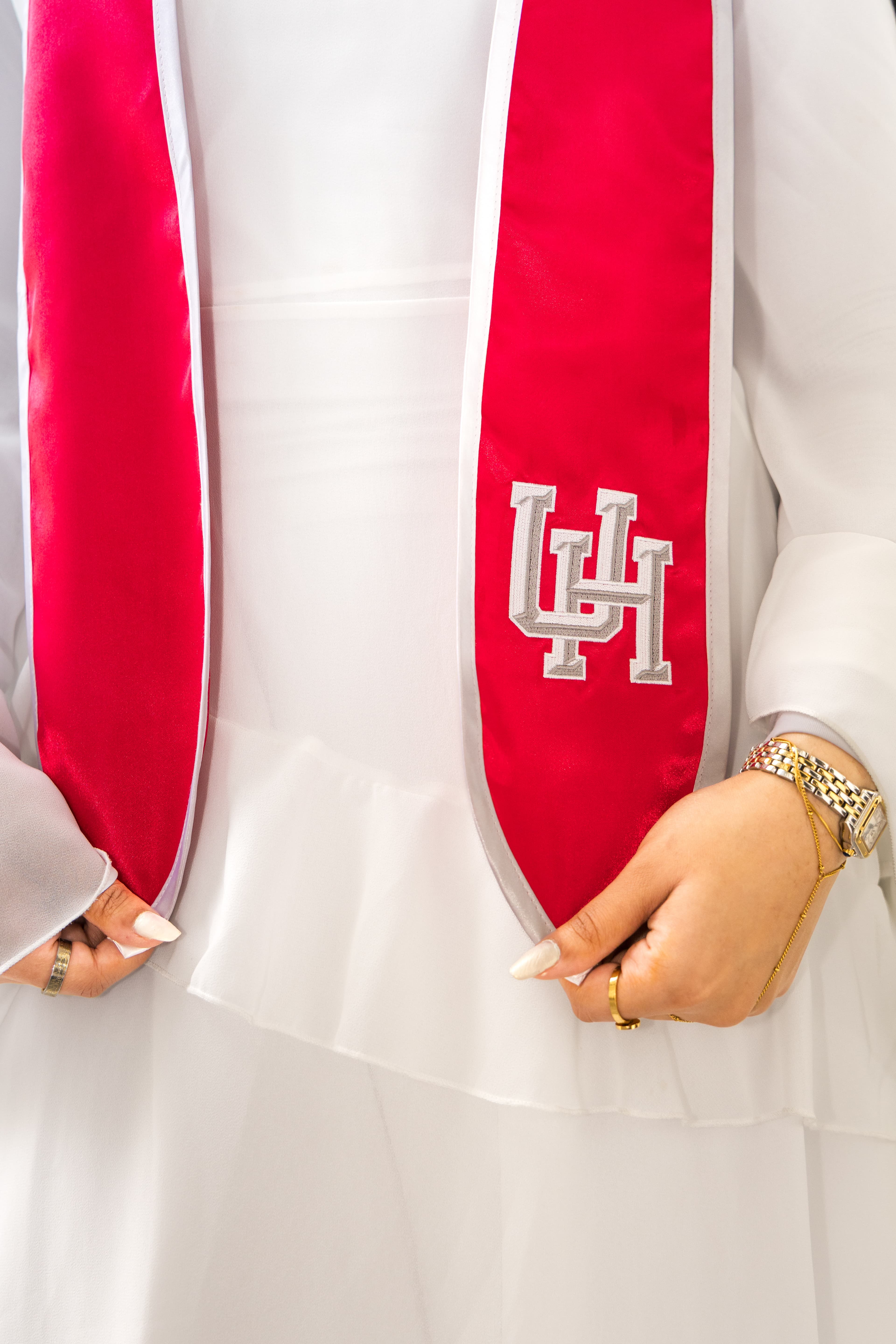 Close-up of hands holding a University of Houston graduation stole