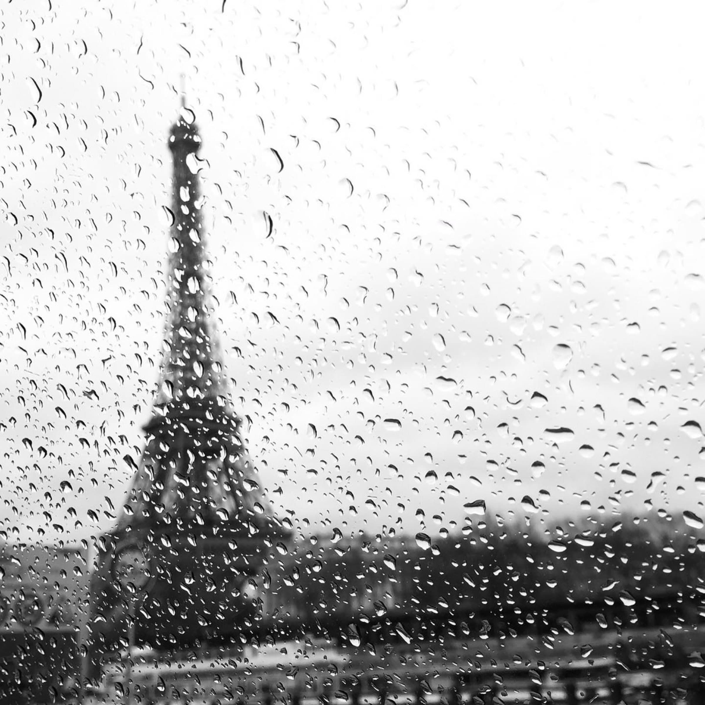 Eiffel Tower seen through a rain-speckled window in black and white