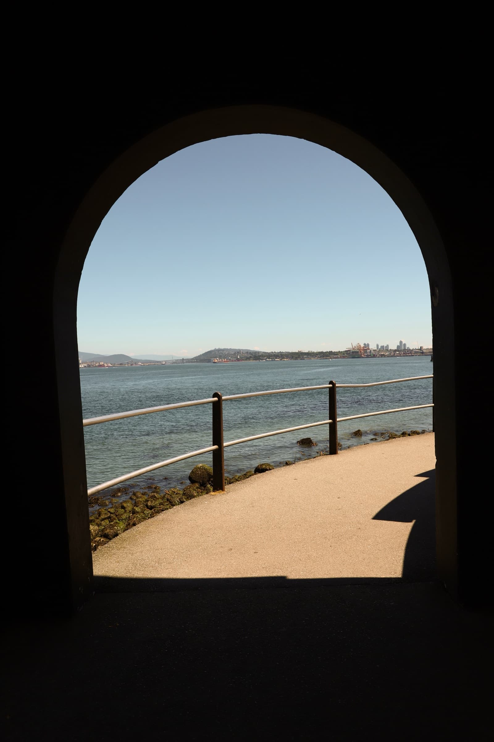 City skyline and harbor framed by a stone archway
