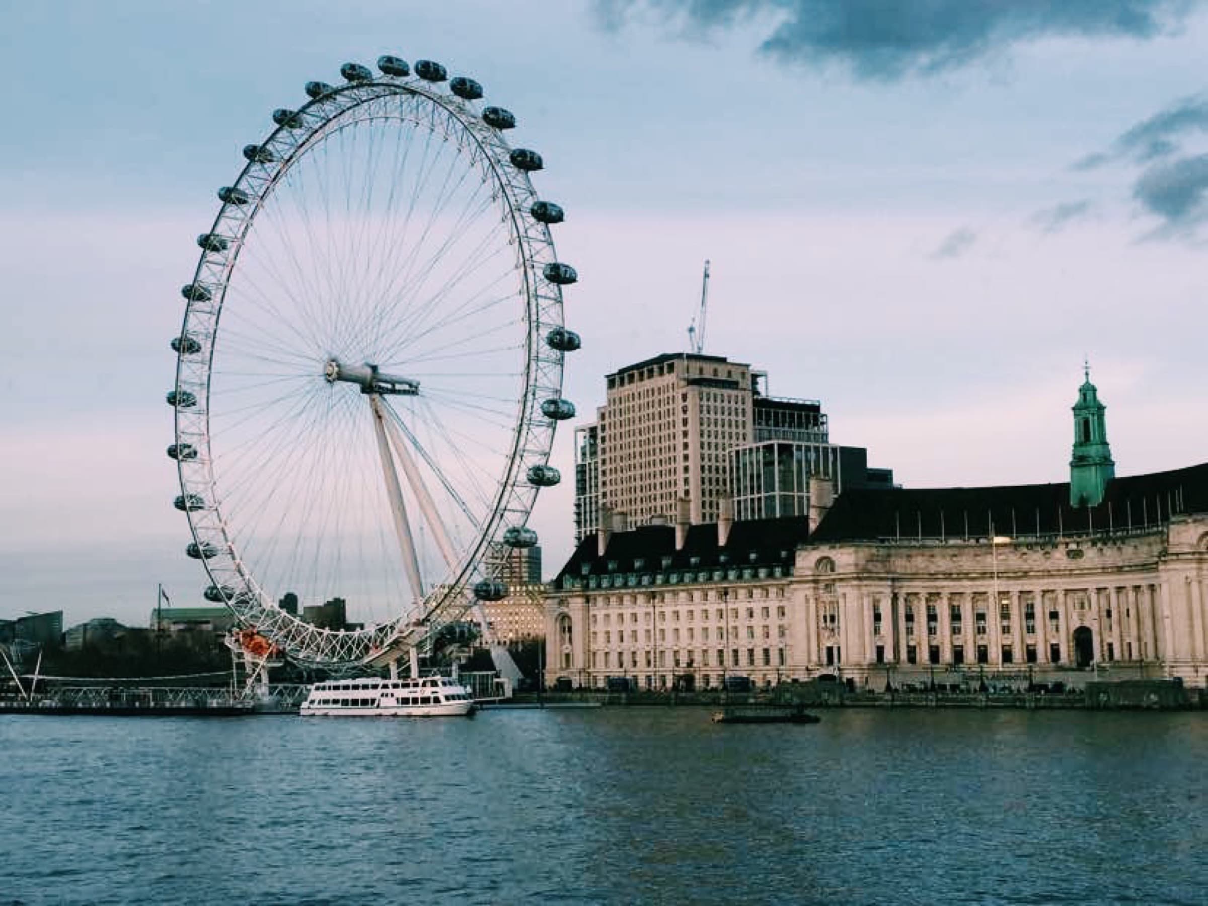 London Eye ferris wheel at dusk beside the River Thames and County Hall