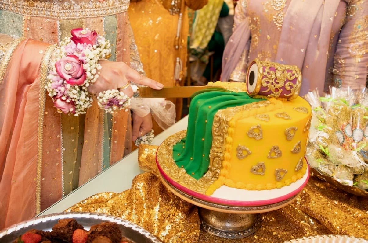 Bride and groom cutting a yellow and green wedding cake