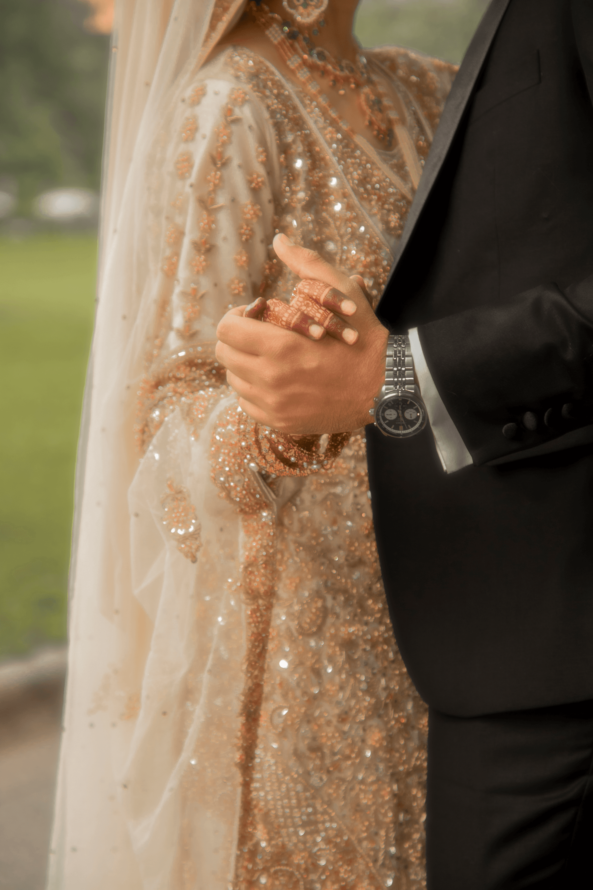 Bride and groom embracing under a beaded veil outdoors