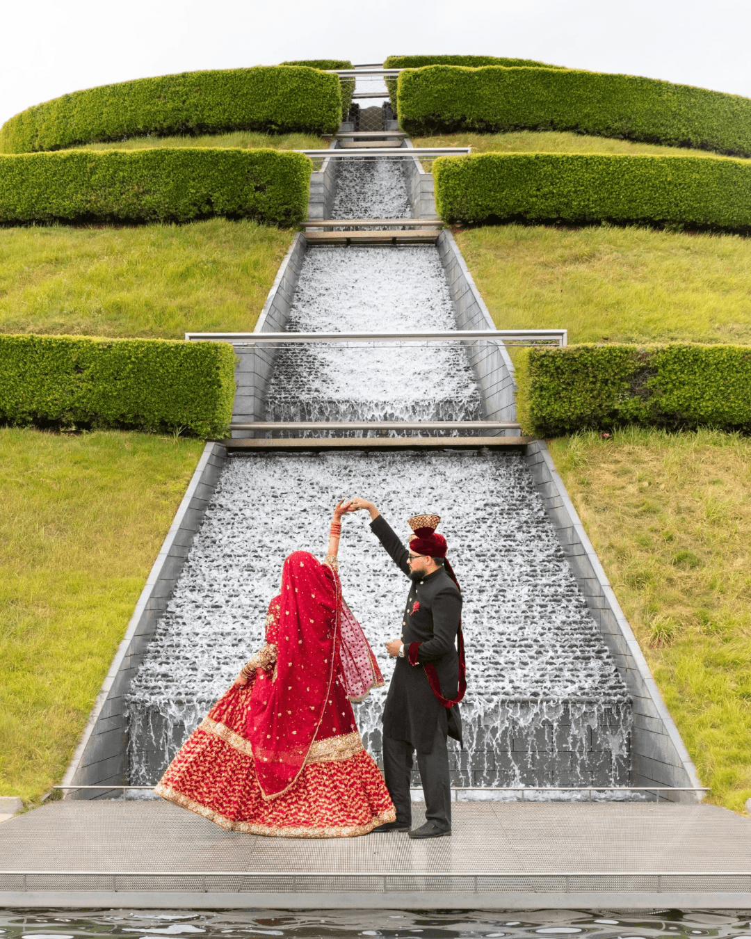 Bride and groom dancing in front of a terraced water fountain