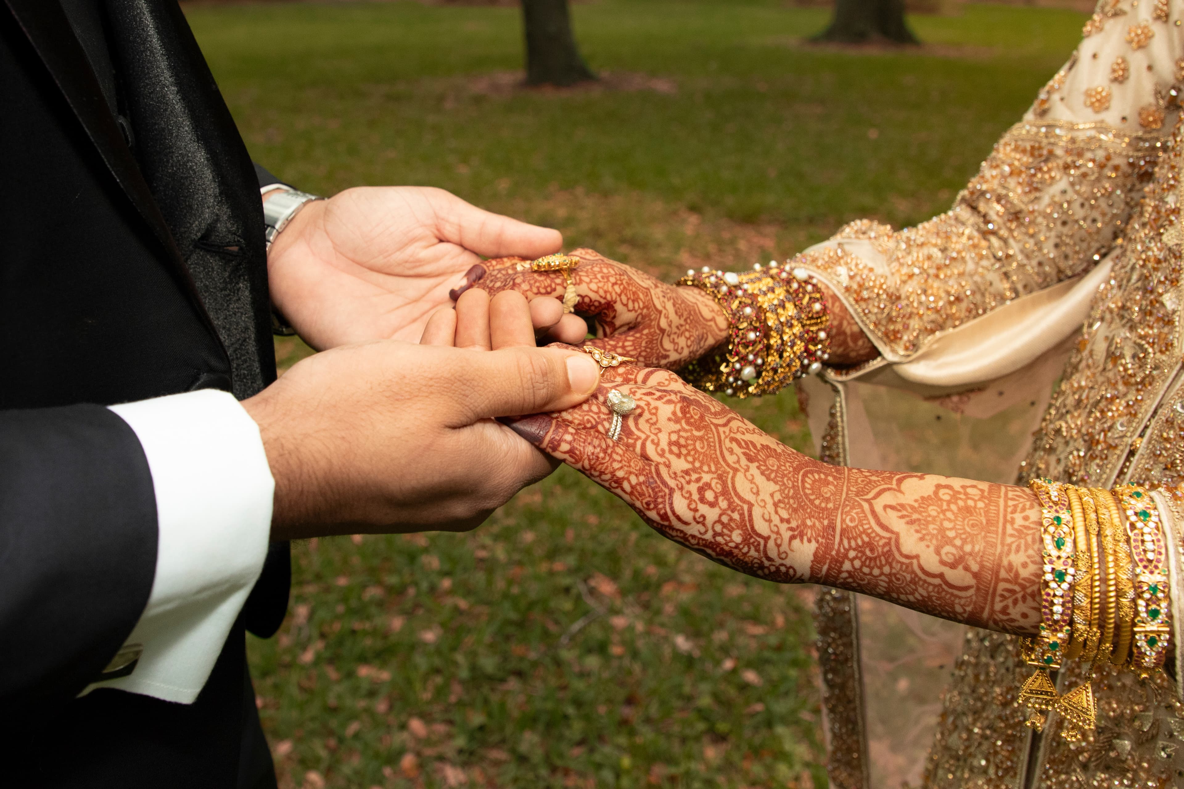Close up of a wedding ring being placed on a bride's hand