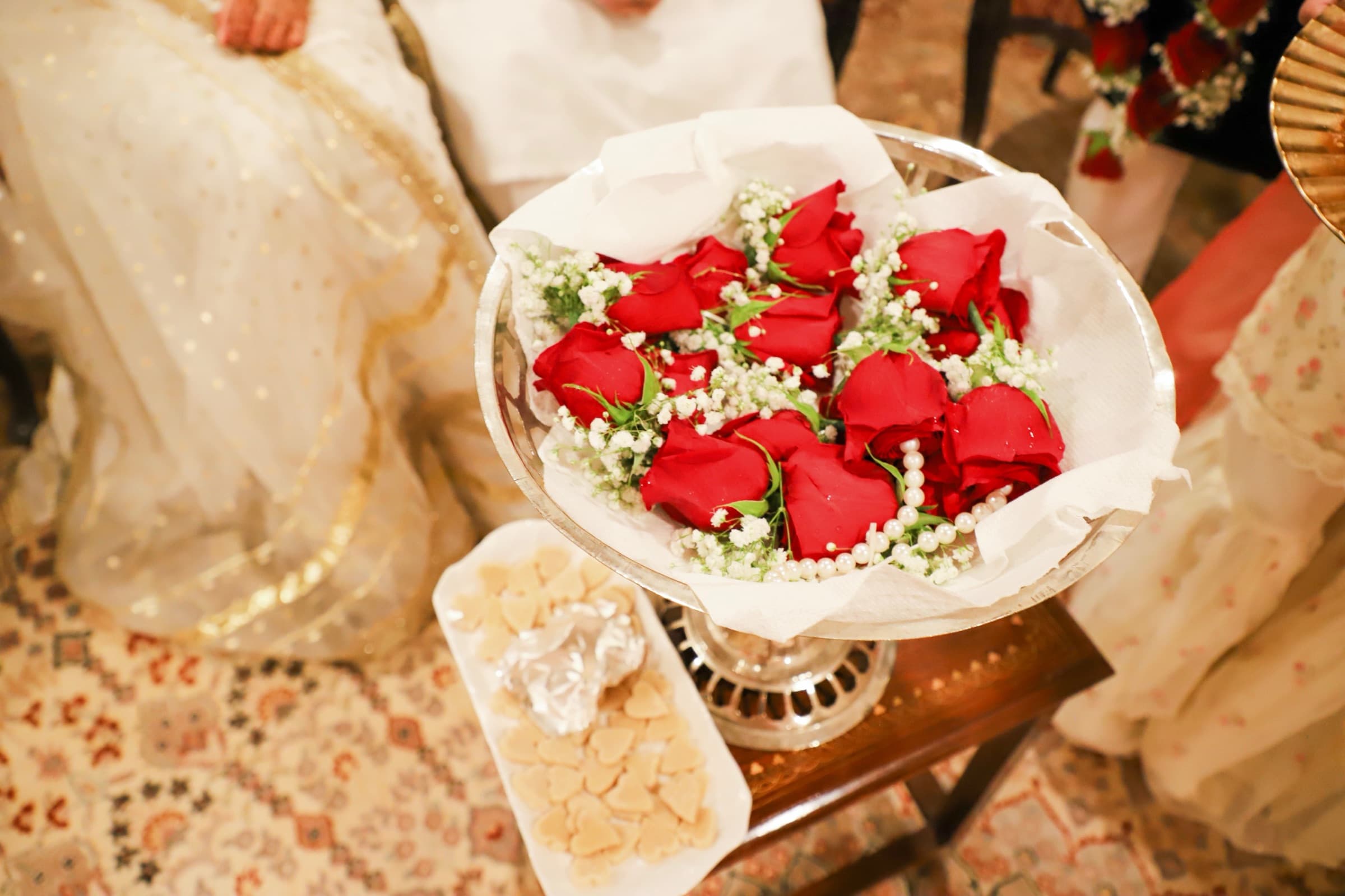 Silver tray of red roses and pearls used in a wedding ceremony